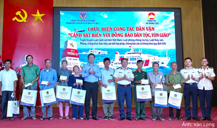 Thượng tá Phan Thanh Hải, Chính trị viên Đoàn đặc nhiệm Phòng chống tội phạm ma tuý số 2 và ông Võ Minh Thế, Bí thư Đảng ủy xã Đông Lộc trao quà cho bà con nhân dân