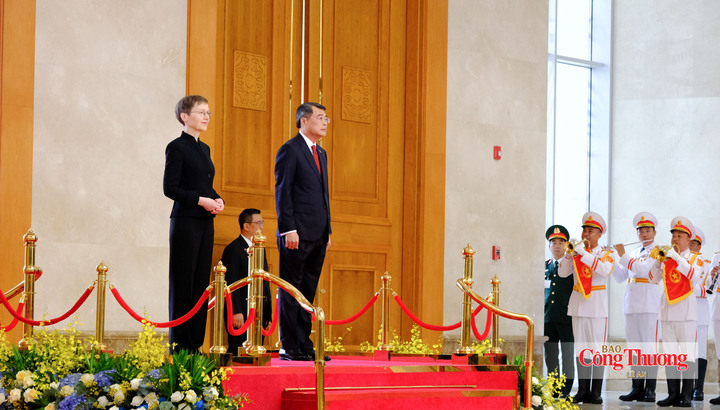 Thủ tướng Lê Minh Hưng và Thủ tướng Liechtenstein Brigitte Haas trên bục danh dự, nghe quân nhạc cử Quốc thiều hai nước.