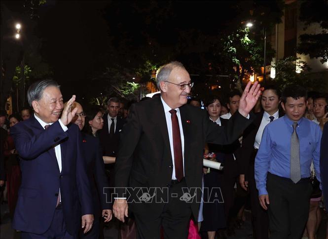 Tổng Bí thư, Chủ tịch nước Tô Lâm và Tổng thống Thụy Sĩ Guy Parmelin vẫy chào du khách và nhân dân Thủ đô khi dạo phố đi bộ hồ Hoàn Kiếm. Ảnh: Thống Nhất - TTXVN