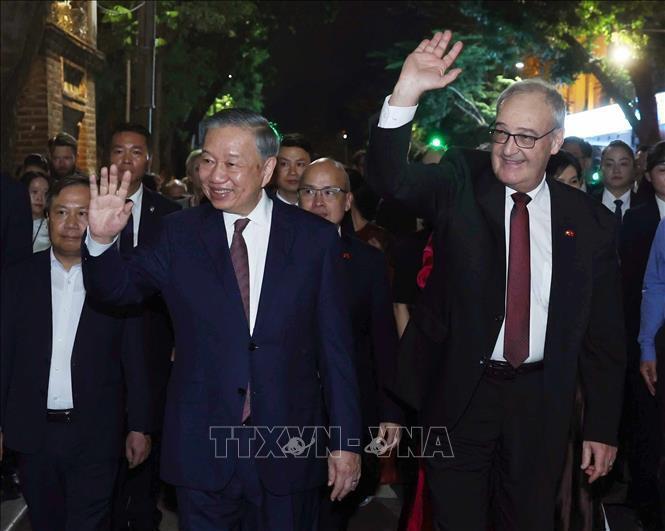 Tổng Bí thư, Chủ tịch nước Tô Lâm và Tổng thống Thụy Sĩ Guy Parmelin vẫy chào du khách và nhân dân Thủ đô khi dạo phố đi bộ hồ Hoàn Kiếm. Ảnh: Thống Nhất - TTXVN