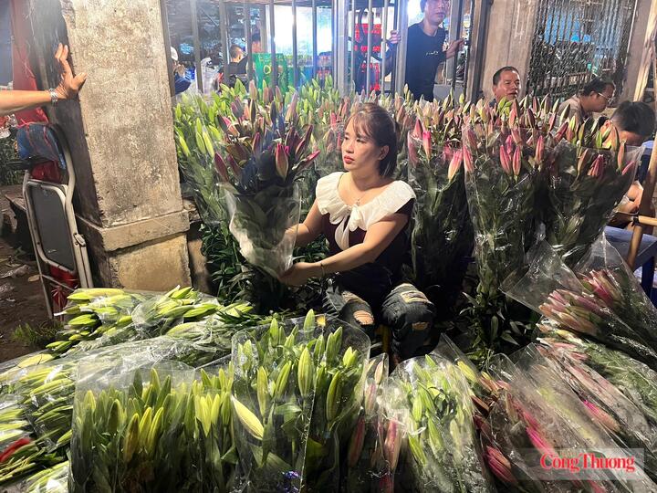 Chị Tuyên, tiểu thương tại chợ hoa Quảng An đang gói hoa cho khách.