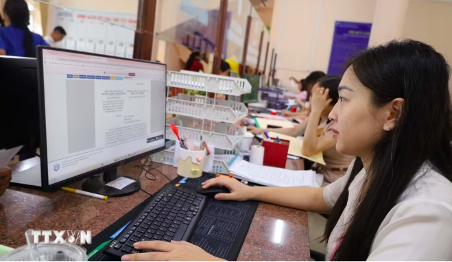Cán bộ, công chức tại Ủy ban Nhân dân phường Chơn Thành, Đồng Nai làm việc ngoài giờ để bảo đảm giải quyết hồ sơ đúng hạn. (Ảnh: Đậu Tất Thành/TTXVN)