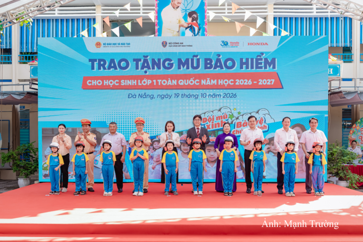 Các đại biểu trao tặng mũ bảo hiểm cho các em học sinh lớp Một trường Tiểu học Ngô Mây
