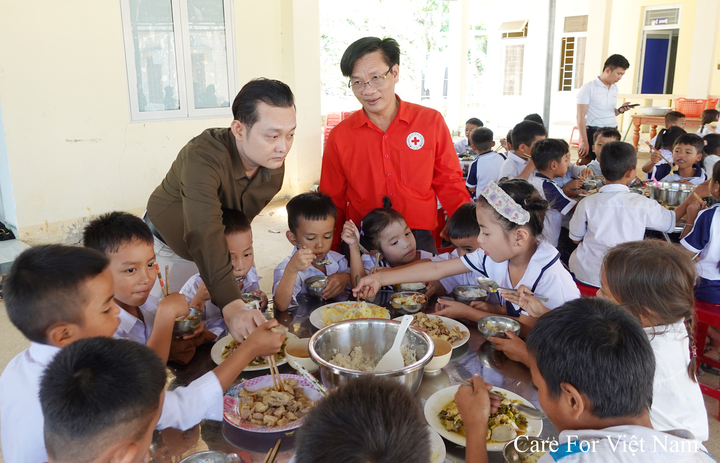 Ông Phạm Tường Huy, Phó Tổng Giám đốc Care For Việt Nam (ngoài cùng bên trái), cùng đại diện Hội Chữ thập đỏ thăm hỏi, động viên các em học sinh trong bữa ăn thuộc chương trình “Chăm em đủ chất”.