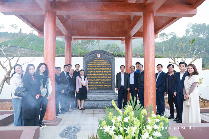 Lãnh đạo, cán bộ, viên chức, người lao động Nhà xuất bản Chính trị quốc gia Sự thật chụp ảnh lưu niệm tại Di tích lịch sử Địa điểm làm việc của Nhà xuất bản tại xóm Cây Hồng (1947-1950), xã Bình Thành, tỉnh Thái Nguyên.