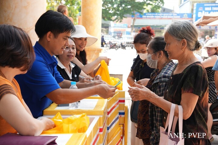 Anh Đỗ Ngọc Tiến, cán bộ PVEP, trao tặng quà cho người dân đến thăm khám. Ảnh: PVEP