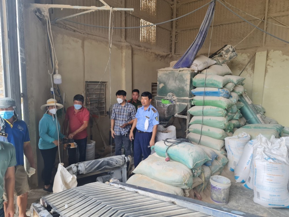 Nhân công đang tháo vỏ bao Cám mỳ phối trộn thêm bột đá để đóng vào vỏ bao mới Nhân công đang tháo vỏ bao Cám mỳ phối trộn thêm bột đá để đóng vào vỏ bao mới