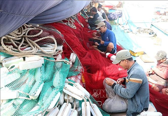 Ngư dân Quảng Trị sửa lưới để chuẩn bị ra khơi. 