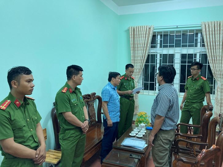 Công an tỉnh Đắk Nông tống đạt các quyết định tố tụng đối với bị can Nguyễn Phi Hùng (Mặc áo kẻ màu xanh bên trái, không đóng thùng). Ảnh: CACC
