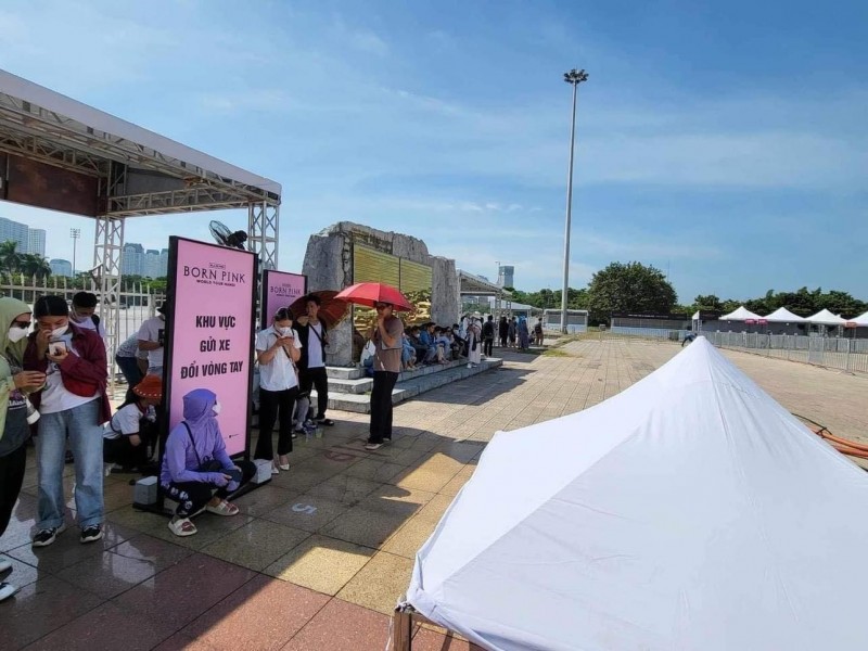 Người hâm mộ đến đổi vé mang theo quạt tay, ô, áo chống nắng... che chắn kín mít. Phần lớn các bạn trẻ gặp khó trong việc nhầm lẫn các hàng đứng do các khu vực lấy vòng tay không phân chia rõ ràng.