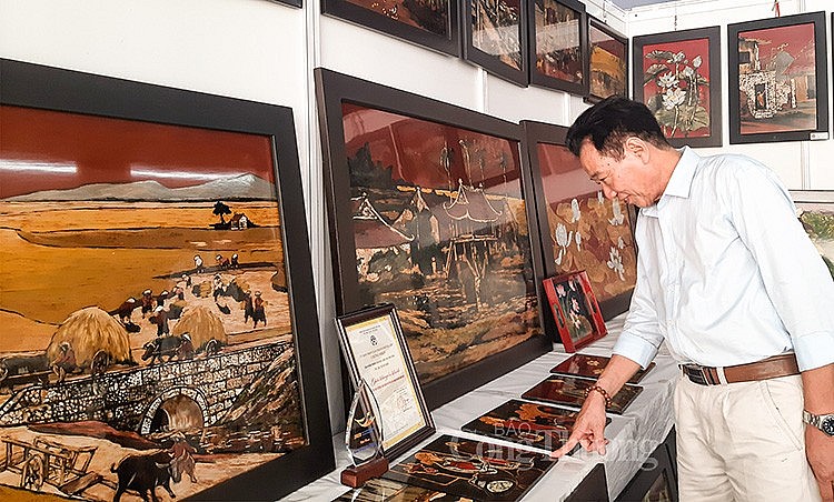 Nghệ nhân Vũ Huy Mến làng nghề sơn mài Hạ Thái (huyện Thường Tín) bên những tác phẩm nghệ thuật của mình (ảnh Nguyễn Hạnh)