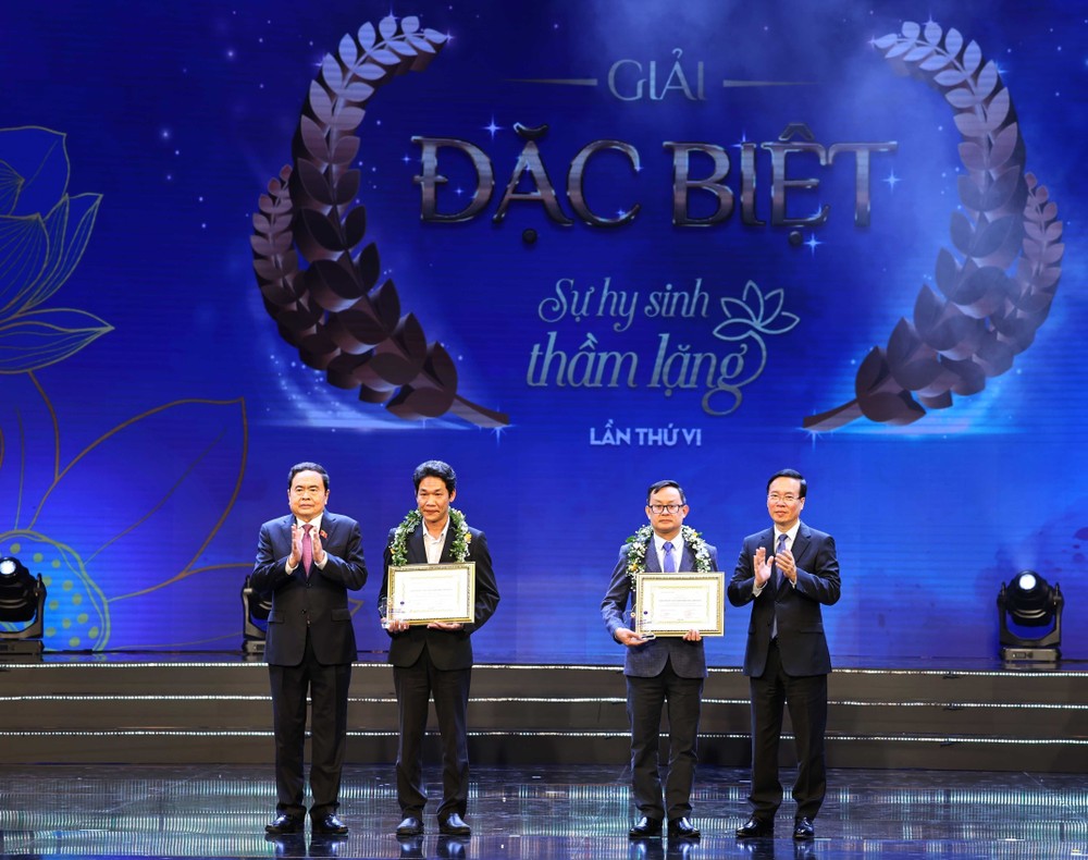 Chủ tịch nước Võ Văn Thưởng và Phó Chủ tịch Thường trực Quốc hội Trần Thanh Mẫn trao Giải Đặc biệt cho tác giả Ngô Anh Văn (Báo Sức khoẻ & Đời sống) và trao chứng nhận cho nhân vật trong tác phẩm đoạt giải là Bác sỹ Võ Thái Trung, Phó trưởng Khoa Chấn thương-Chỉnh hình (Bệnh viện Đa khoa tỉnh Bình Dương. (Ảnh: Thống Nhất/TTXVN) ttxvn_chu_tich_nuoc_vo_van_thuong__du_chuong_trinh_ton_vinh_thay_thuoc_viet_nam_2602-2.jpg