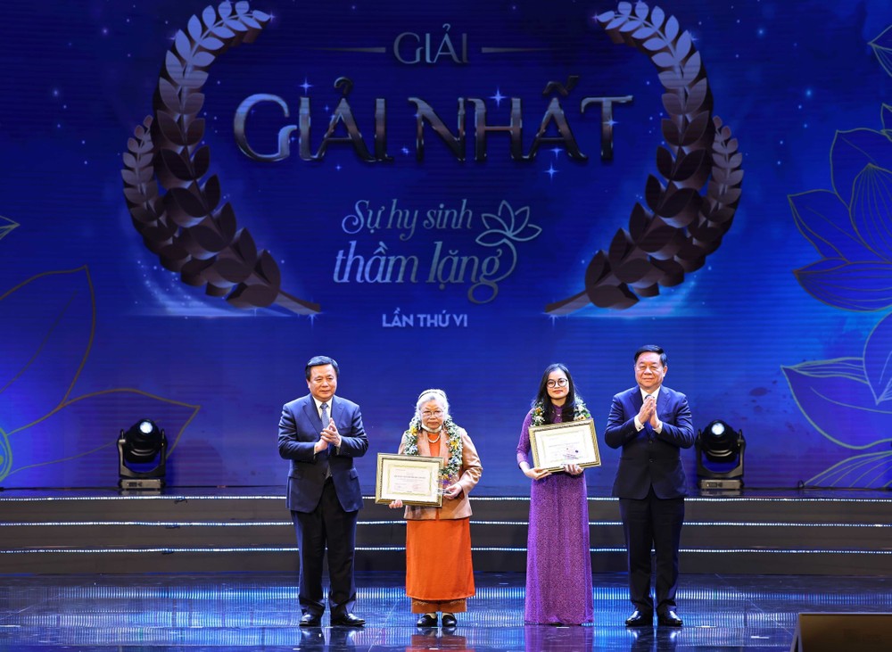 Ông Nguyễn Xuân Thắng, Ủy viên Bộ Chính trị, Giám đốc Học viện Chính trị quốc gia Hồ Chí Minh, Chủ tịch Hội đồng Lý luận Trung ương và ông Nguyễn Trọng Nghĩa, Bí thư Trung ương Đảng, Trưởng ban Tuyên giáo Trung ương trao giải Nhất cho tác giả và chứng nhận cho nhân vật trong tác phẩm đoạt giải. (Ảnh: Thống Nhất/TTXVN) ttxvn_chu_tich_nuoc_vo_van_thuong__du_chuong_trinh_ton_vinh_thay_thuoc_viet_nam_2602-3.jpg