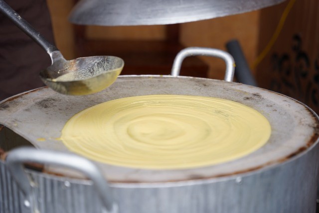 Tráng bột ngô làm bánh phở. (Ảnh hagiang.gov) Tráng bột ngô làm bánh phở. (Ảnh hagiang.gov)