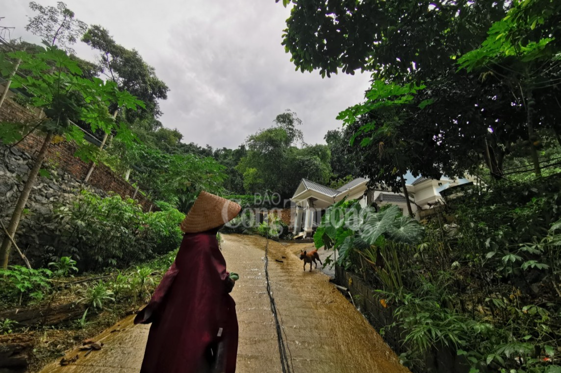 Một người thân gia đình anh Thắng tiếc nuối ngoái lại nhìn căn biệt thự sau khi ra khỏi khu vực nguy hiểm.