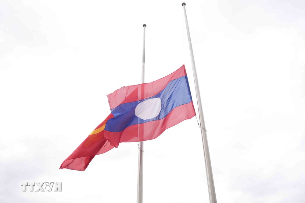 Quốc kỳ của Lào được kéo xuống theo nghi lễ Quốc tang. (Ảnh: Đỗ Bá Thành/TTXVN) ttxvn_quoc tang tai lao (1)_resize.jpg