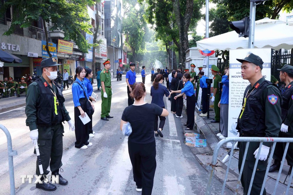 Lực lượng vũ trang hỗ trợ người dân đến viếng Tổng Bí thư Nguyễn Phú Trọng tại Nhà tang lễ Quốc gia số 5 Trần Thánh Tông, Hà Nội, sáng 26/7. (Ảnh: TTXVN) TTXVN_2607nguoidan12.jpg