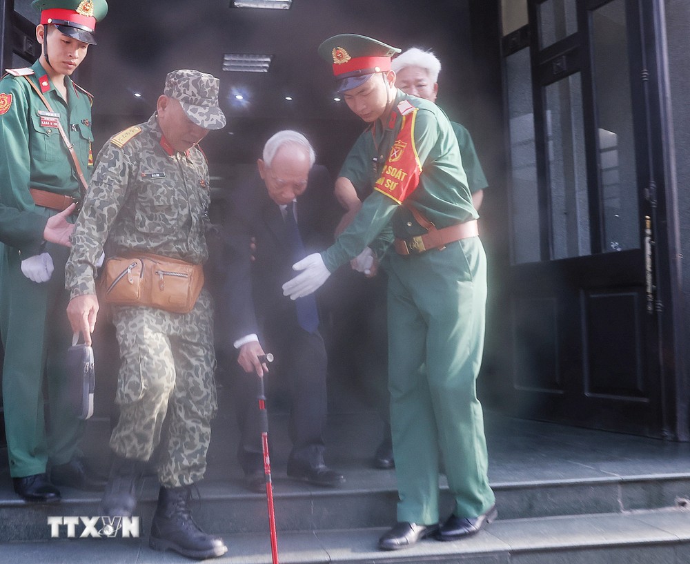 Lực lượng quân đội giúp người dân đến viếng Tổng Bí thư Nguyễn Phú Trọng tại Nhà tang lễ Quốc gia số 5 Trần Thánh Tông, Hà Nội, sáng 26/7. (Ảnh: TTXVN) TTXVN_2607nguoidan3.jpg