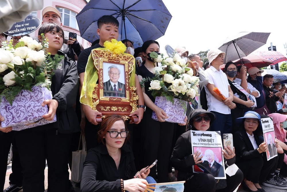 Người dân thủ đô Hà Nội đổ ra đường chờ đoàn xe tang qua. (Ảnh: TTXVN) nguoi_dan_thu_do_cho_tien_biet_tong_bi_thu_nguyen_phu_trong9_resize.jpg