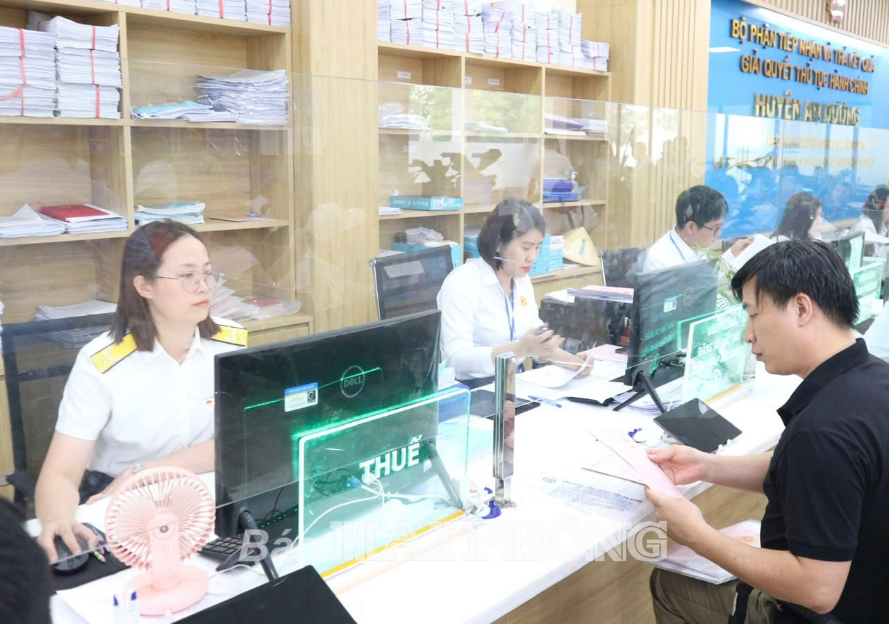 Cán bộ Chi cục Thuế khu vực Hồng Bàng - An Dương, Hải Phòng hướng dẫn người dân thực hiện thủ tục nộp thuế. Ảnh: Hà Minh