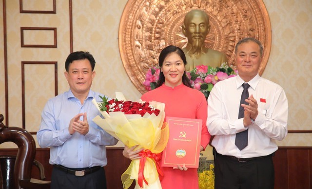 Ủy viên Ban Thường vụ, Trưởng Ban Tổ chức Tỉnh ủy Nguyễn Hồng Trà; Tỉnh ủy viên, Chánh Văn phòng Tỉnh ủy Đặng Hà Giang trao quyết định và tặng hoa chúc mừng Thư ký Bí thư Tỉnh ủy Dương Thị Thảo. Ảnh: Chinhphu.vn