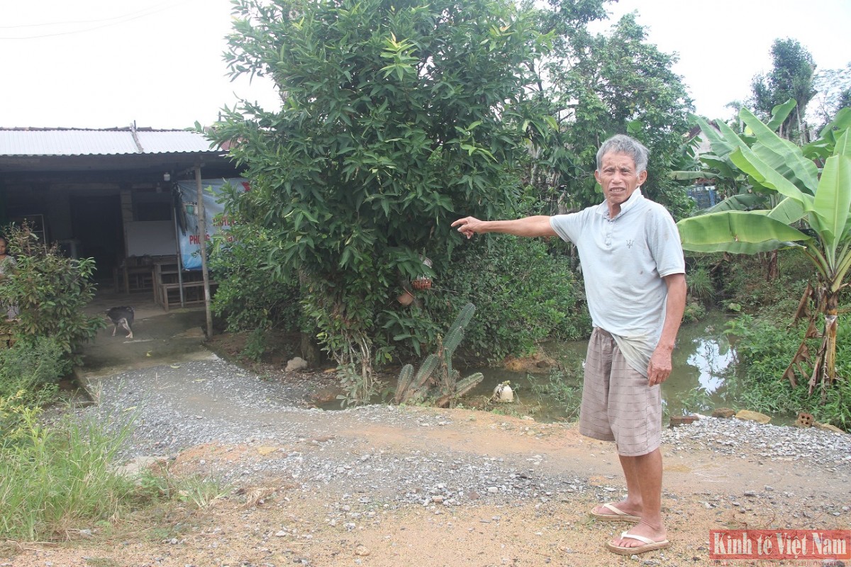 Ông Nguyễn Dõng chỉ mặt đường cao hơn nhà mình gần 2m