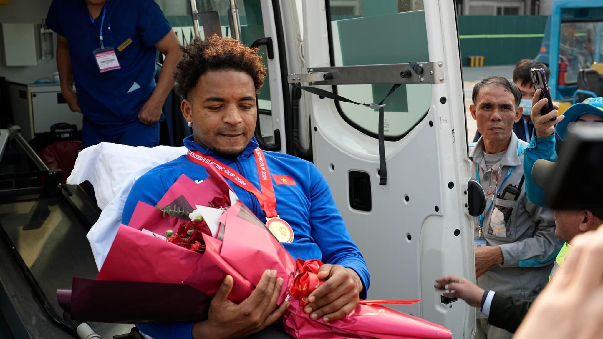 Nguyễn Xuân Son nén đau lên xe cứu thương nhanh chóng rời sân bay để về nơi được đội ngũ y tế chăm sóc. Ảnh: NIA