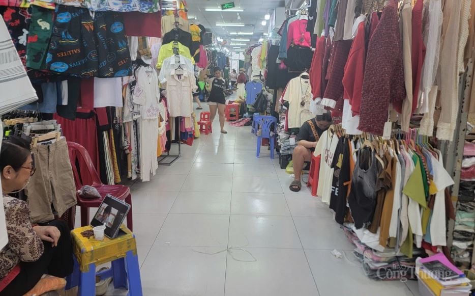 Vắng khách, nhiều tiểu chợ An Đông ngồi chơi điện thoại.