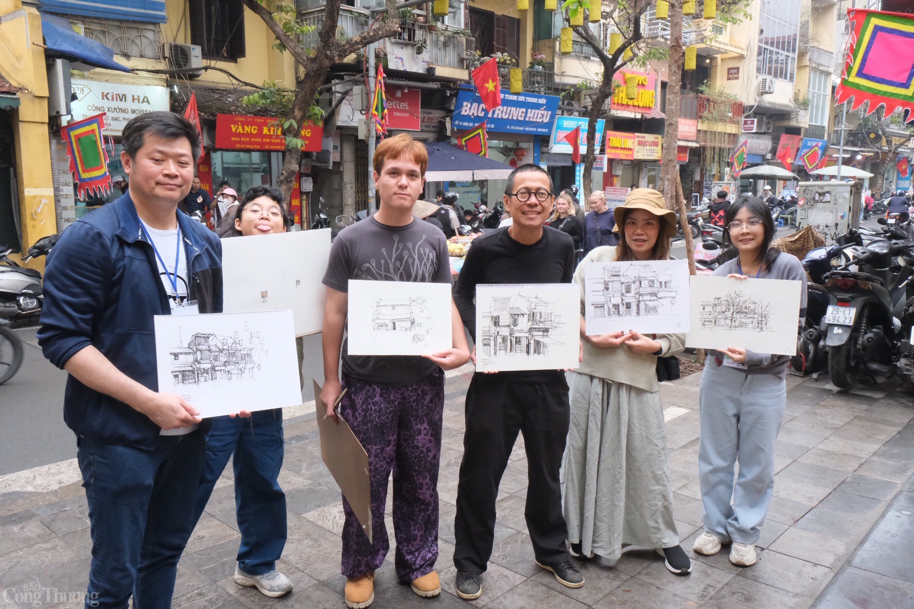 Các du khách Thái Lan thích thú khi hoàn thành bản vẽ với chủ đề phố cổ Hà Nội. Ảnh: Lê An