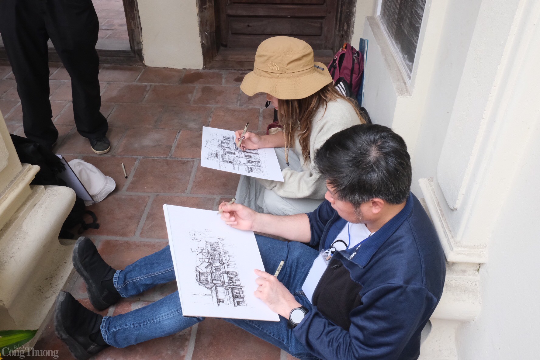 Đáng chú ý, khi tới cổng đình, một nhóm họa người Thái Lan đang tập trung, hướng dẫn phác họa những nét kiến trúc tại phố cổ. Ảnh: Lê An