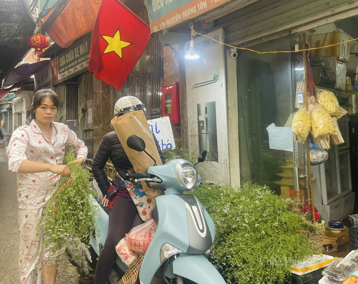 Tiểu thương đang bó lá mùi già cho người mua. Ảnh: Nguyễn Vy