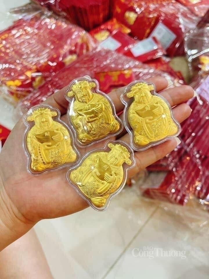 mỗi hình ông Thần tài đính kèm trong bao lì xì được làm từ hợp kim mỏng và phủ nhũ vàng bắt mắt. Ảnh: Nguyễn Vân mỗi hình ông Thần tài đính kèm trong bao lì xì được làm từ hợp kim mỏng và phủ nhũ vàng bắt mắt. Ảnh: Nguyễn Vân
