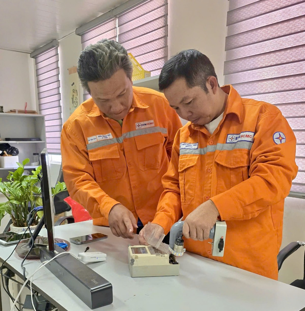 Anh Trần Quang Duy (người bên phải) đang hướng dẫn đồng nghiệp thực hiện cải tiến kỹ thuật 