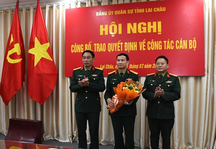 Lãnh đạo Bộ CHQS tỉnh Lai Châu trao quyết định, tặng hoa chúc mừng cán bộ được điều động. Ảnh: Quân đội nhân dân