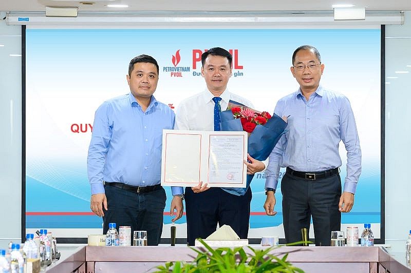 Ông Cao Hoài Dương - Bí thư Đảng ủy, Chủ tịch HĐQT Tổng công ty (bên phải) và ông Nguyễn Đăng Trình - Phó Bí thư Đảng ủy, Tổng Giám đốc Tổng công ty (bên trái) trao quyết định và tặng hoa chúc mừng ông Lê Trung Hưng