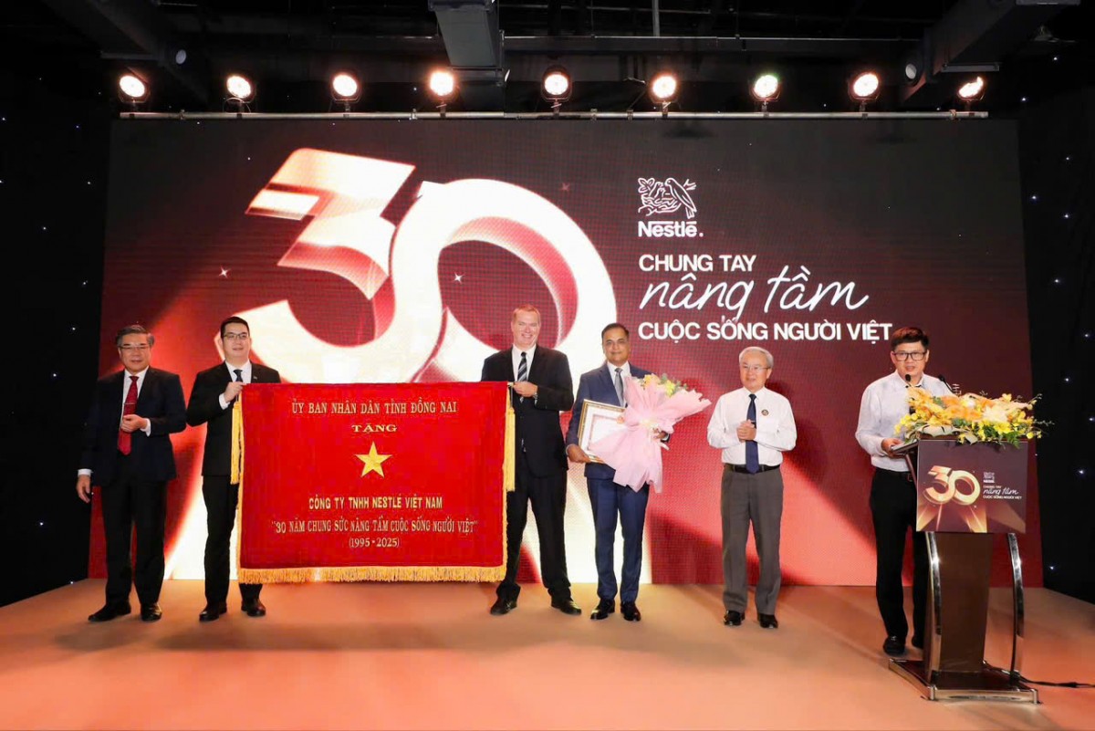 Đại diện tỉnh Đồng Nai trao tặng bức trướng “30 Năm chung sức nâng tầm cuộc sống người Việt” cho Nestlé Việt Nam.
