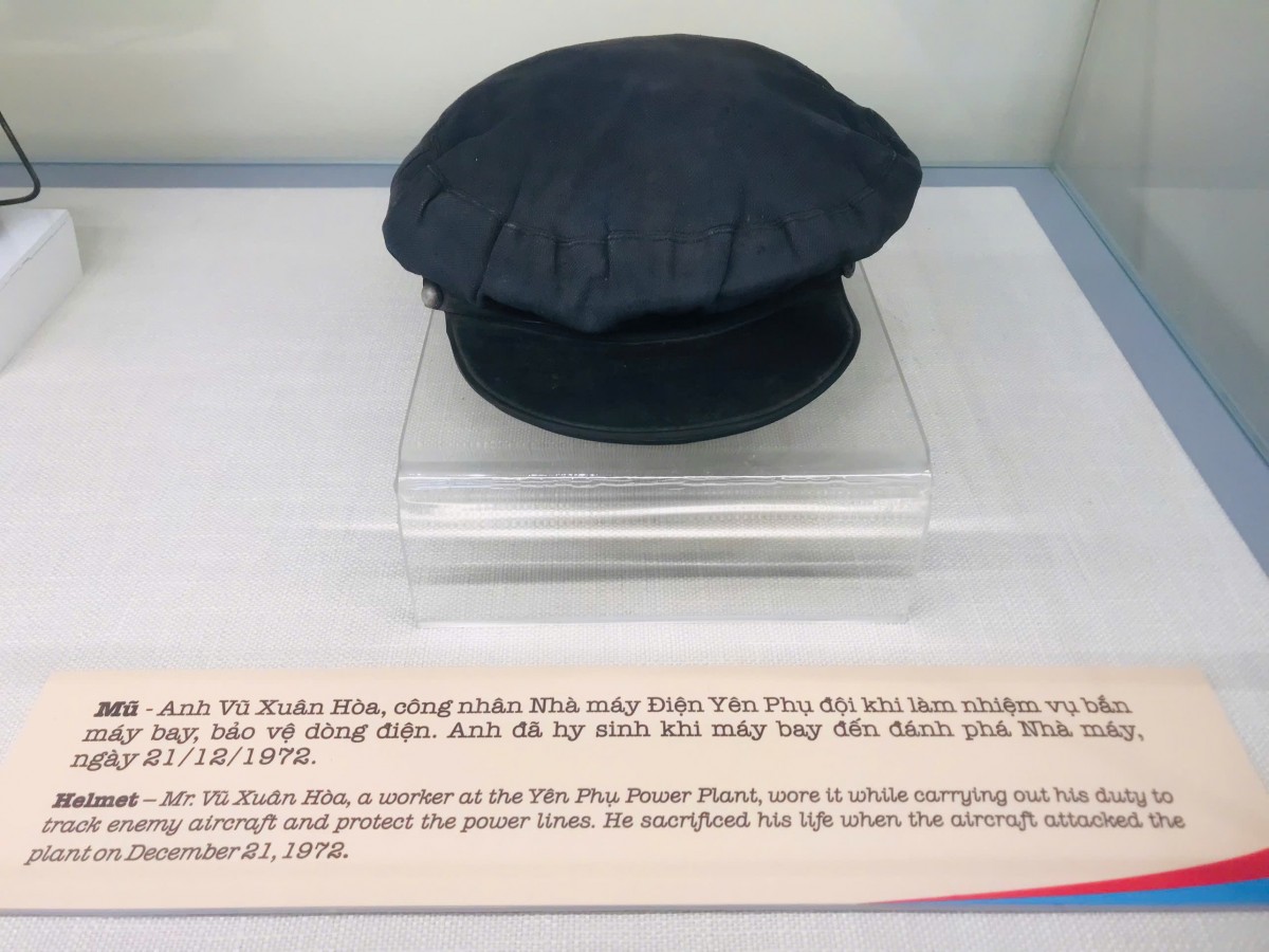 Mũ - Anh Vũ Xuân Hoà công nhân nhà máy Điện Yên Phụ đội khi làm nhiệm vụ bắn máy bay bảo vệ dòng điện. Anh đã hy sinh khi máy bay đánh phá Nhà máy ngày 21/12/1972 Mũ - Anh Vũ Xuân Hoà công nhân nhà máy Điện Yên Phụ đội khi làm nhiệm vụ bắn máy bay bảo vệ dòng điện. Anh đã hy sinh khi máy bay đánh phá Nhà máy ngày 21/12/1972