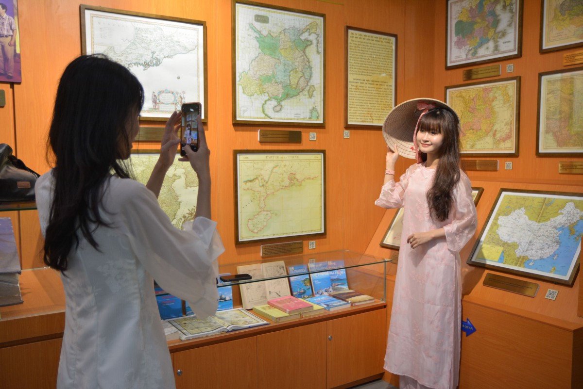 Thế hệ trẻ trong tà áo dài truyền thống check-in cùng các tư liệu lịch sử. Ảnh: Ngọc Thảo