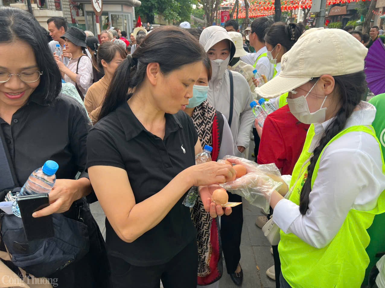 Các tình nguyện viên phát trứng gà cho người dân sau khi chiêm bái xong để bồi bổ sức khoẻ. 
