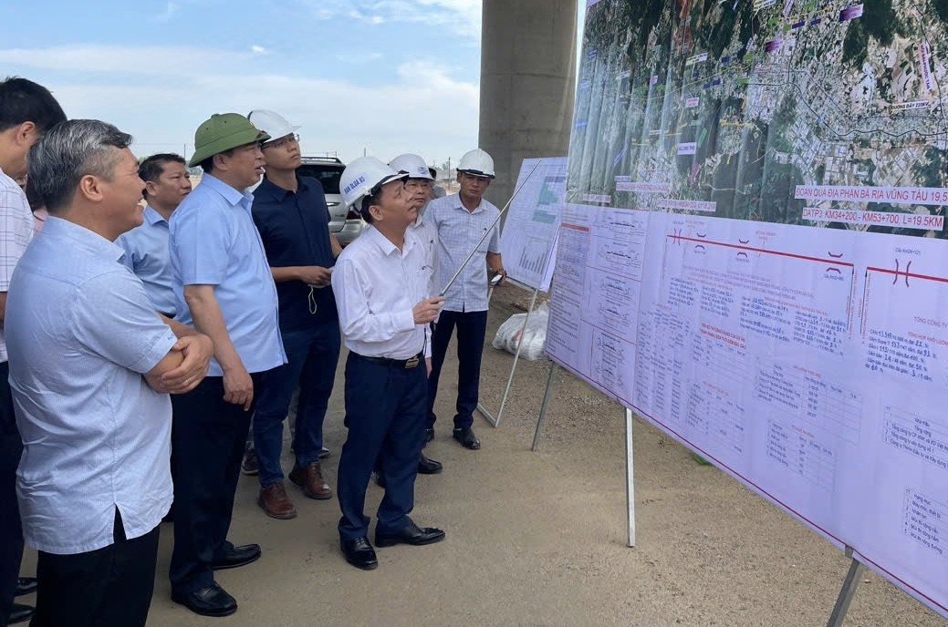 Bộ trưởng Trần Hồng Minh và thành viên đoàn công tác kiểm tra thực địa tại nút giao Tân Hiệp và nghe Ban QLDA 85 báo cáo tiến độ dự án.