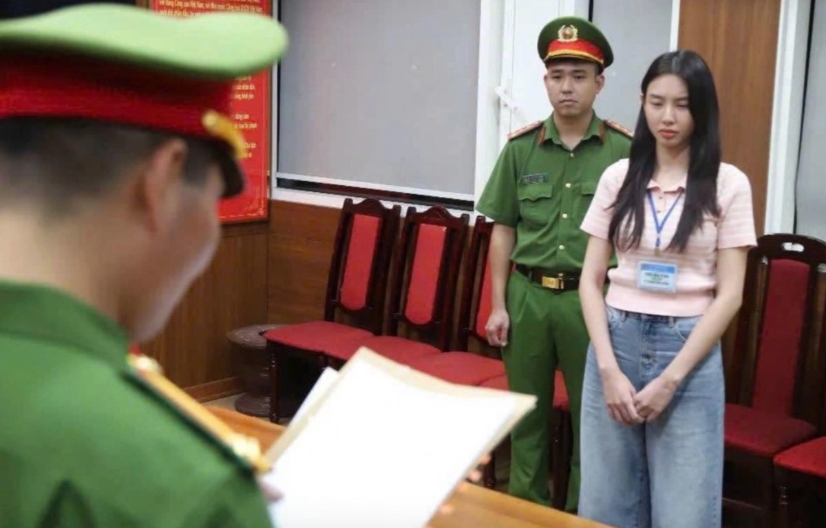 Hoa hậu Thùy Tiên (phải) nghe cảnh sát đọc lệnh khởi tố, bắt tạm giam, ngày 19/5. Ảnh: Bộ Công an