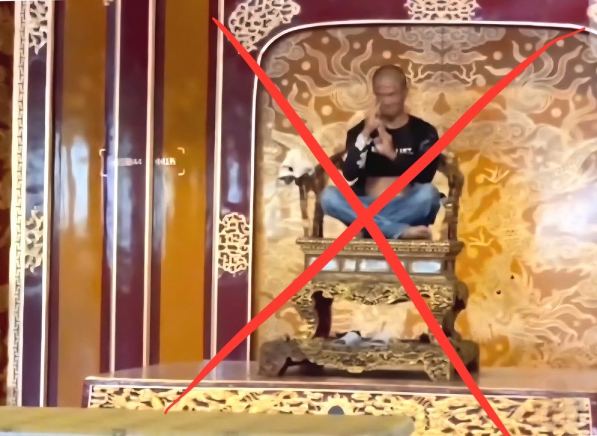 Đối tượng Hồ Văn Phương Tâm (trú tại Huế) leo lên ngai vua, làm hư hỏng cấu kiện của Bảo vật quốc gia. (Ảnh chụp màn hình clip)