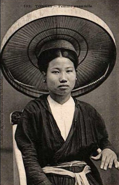 Một phụ nữ mặc áo mớ ba mớ bảy, quấn ruột tượng quanh thắt lưng.