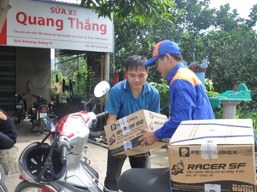 Anh Lê Văn Kiều (phải) đưa dầu nhờn đến tận tay người tiêu dùng.