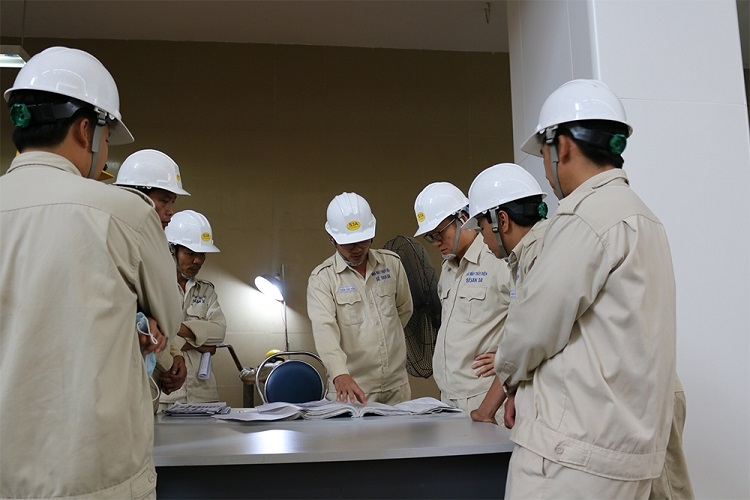 Nhóm kỹ sư, công nhân kỹ thuật hội ý trước khi quyết định xử lý vấn đề về thiết bị Nhóm kỹ sư, công nhân kỹ thuật hội ý trước khi quyết định xử lý vấn đề về thiết bị