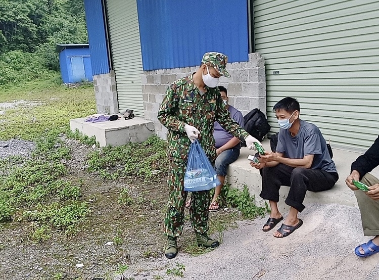 Cán bộ Đồn Biên phòng Quang Long phát khẩu trang, nước sát khuẩn tay và hướng dẫn người dân cách phòng, chống dịch Covid-19