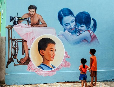 Hai cháu nhỏ của gia đình xem hình ảnh của chính mình trên bức bích họa