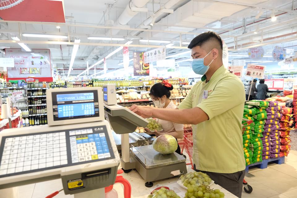 Người ti&amp;ecirc;u d&amp;ugrave;ng chọn mua h&amp;agrave;ng tại si&amp;ecirc;u thị tr&amp;ecirc;n địa b&amp;agrave;n quận Cầu Giấy. Ảnh: C&amp;ocirc;ng H&amp;ugrave;ng