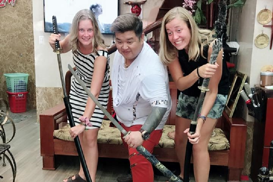 Du khách thích thú khi được anh Hưng biểu diễn cắt tóc bằng kiếm Nhật và vui vẻ chụp hình lưu niệm cùng anh.