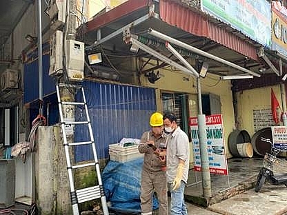 Công nhân Điện lực hướng dẫn khách hàng theo dõi, kiểm soát sản lượng điện tiêu thụ qua APP chăm sóc khách hàng trên thiết bị di động